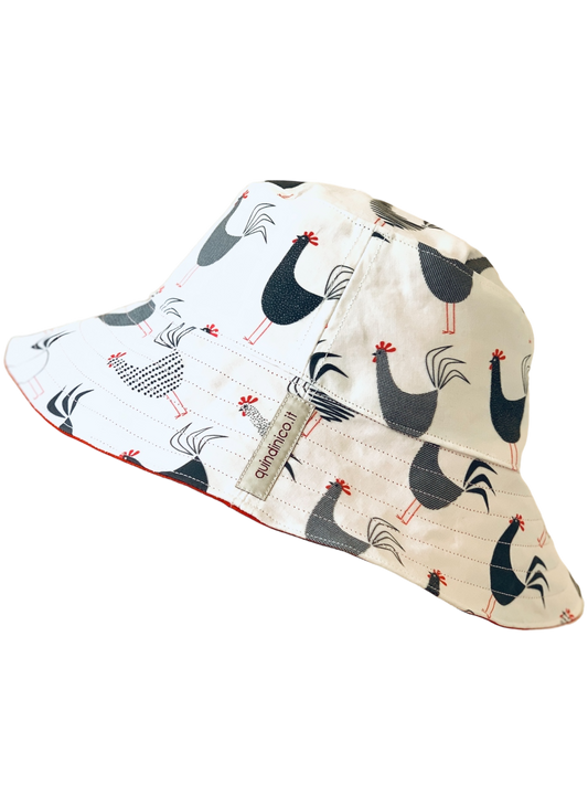 Cappello reversibile in cotone fantasia galletti con interno tinta unita rosso